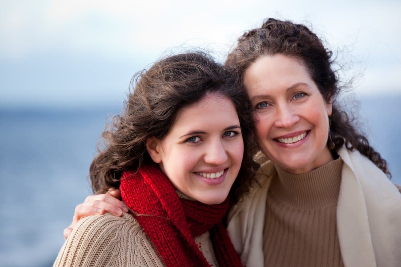 two white women side hugging and smiling at camera