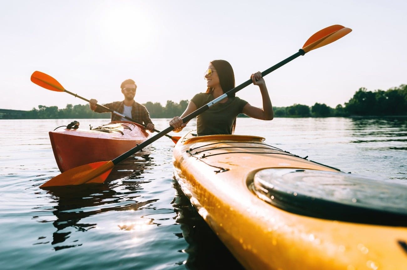 two people smiling and kayaking