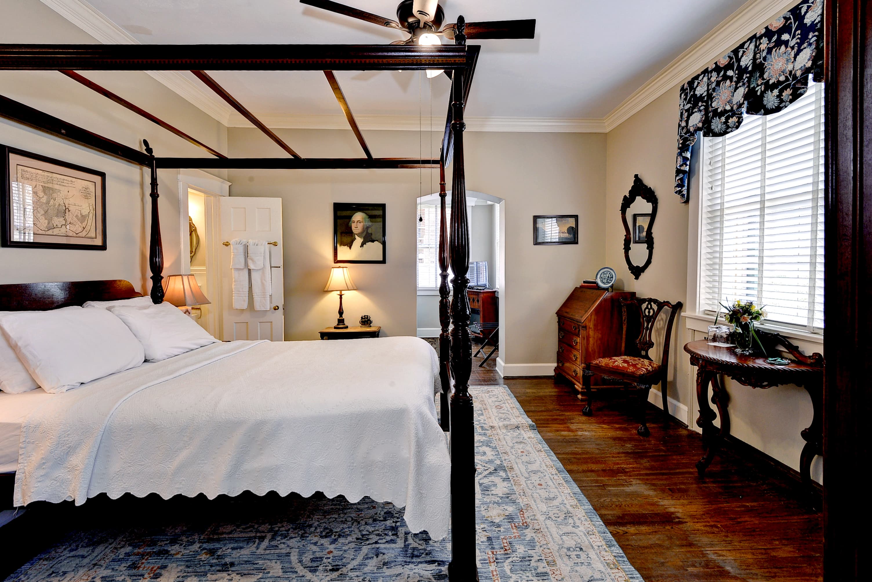 Antique desk and chair with red velvet cushion, wooden side table with lamp