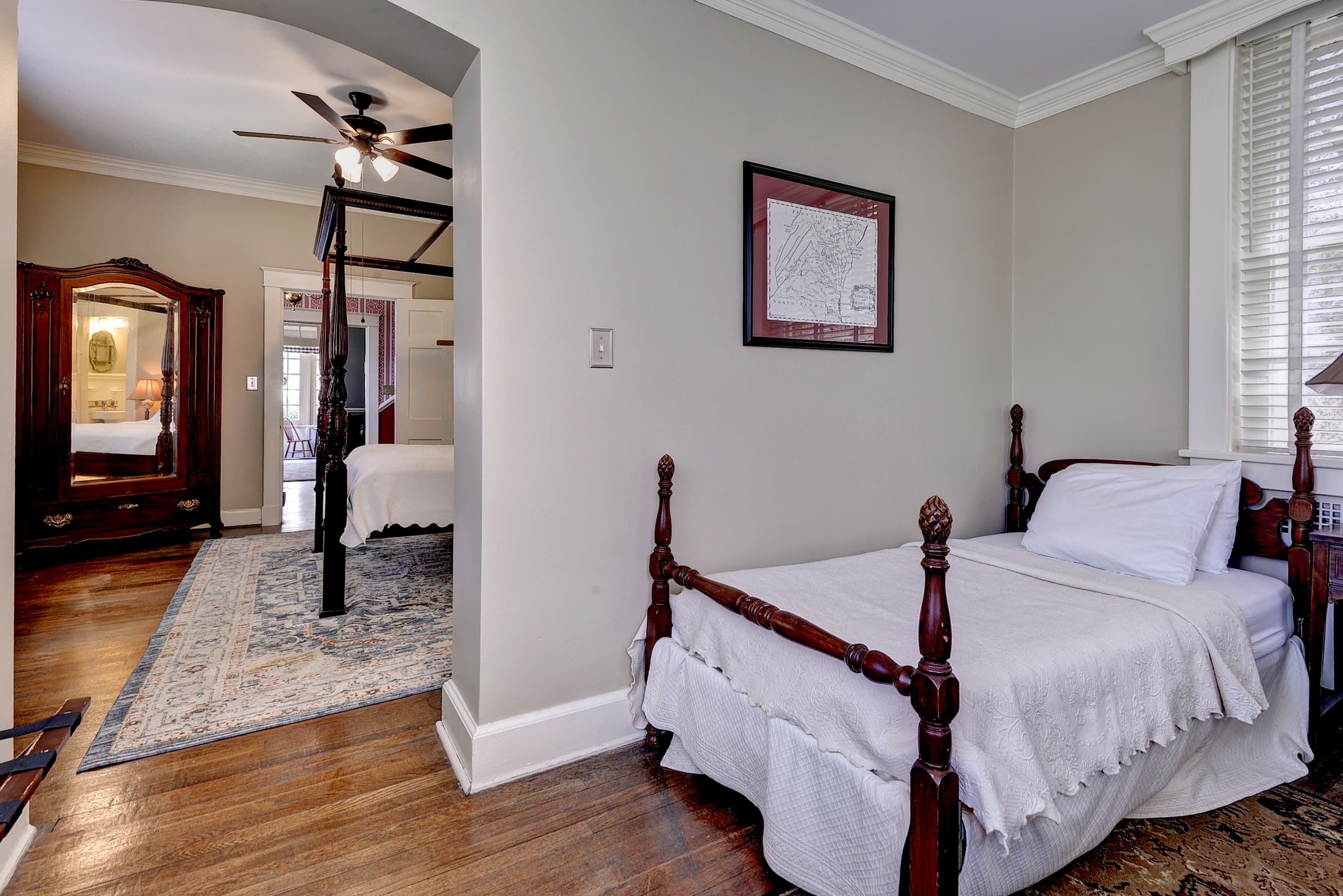 Separate bedroom area with twin bed and open archway leading into the main bedroom