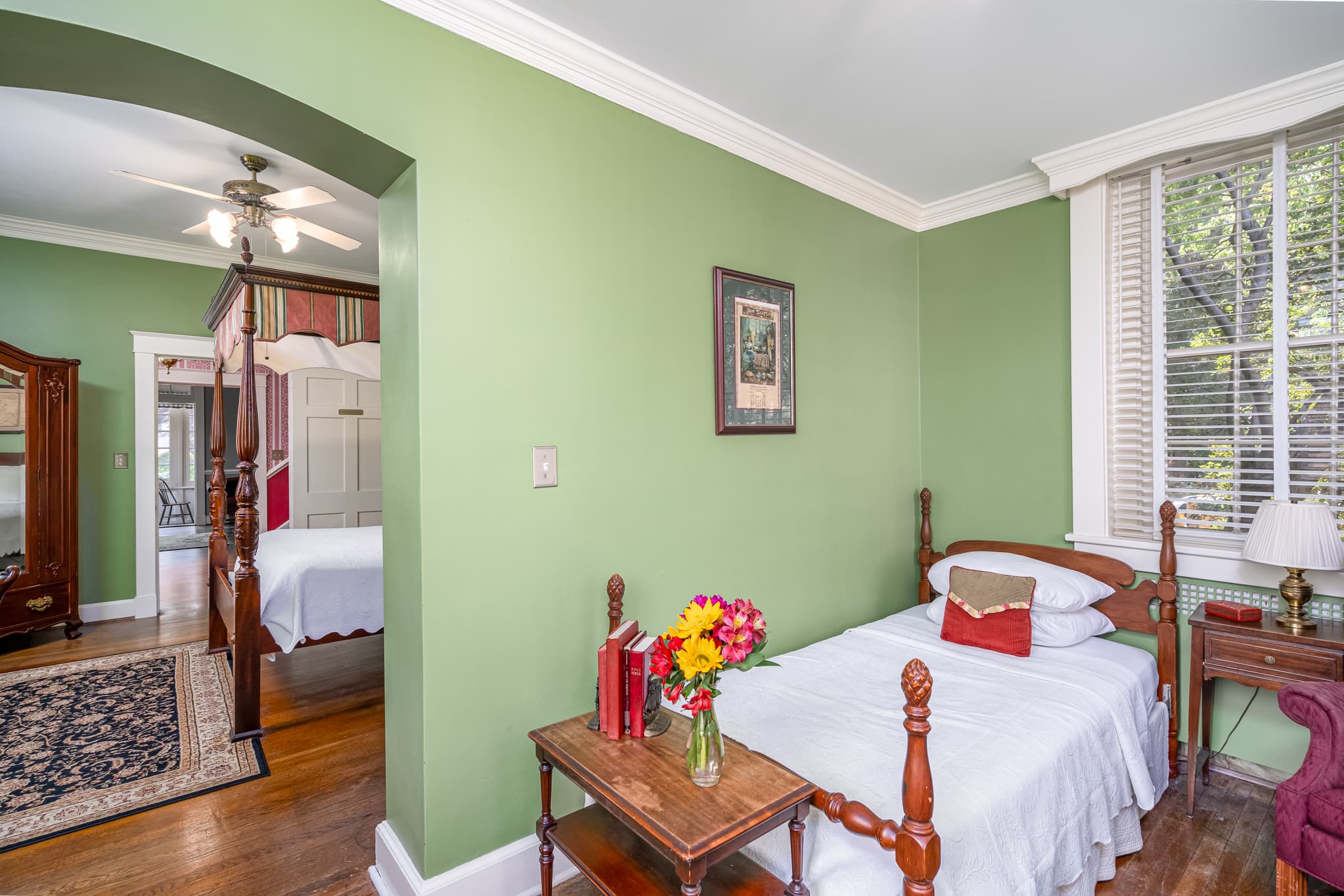 Separate bedroom area with twin bed and open archway leading into the main bedroom